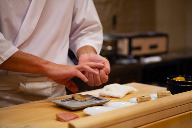プロの寿司職人が慎重に右の圧力だけを使用して自信を持って完璧な寿司と献身にします。 - 寿司 ストックフォトと画像