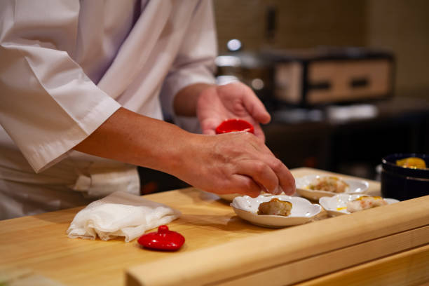 istock Professional and experienced sushi chef carefully add final touch with confident and dedication to his perfect sushi. 1014436542