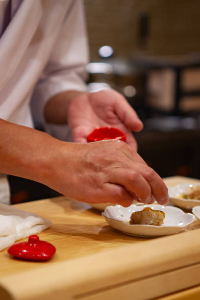 istock Professional and experienced sushi chef carefully add final touch with confident and dedication to his perfect sushi. 1014436548
