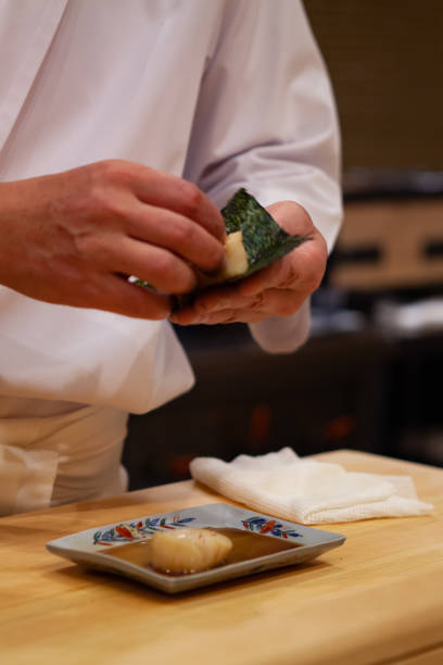 istock Professional and experienced sushi chef is focus and carefully make sushi with confident and dedication to perfection. 1014436664