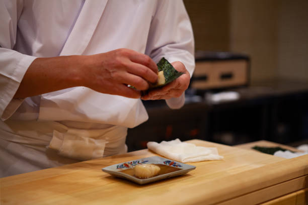 istock Professional and experienced sushi chef is focus and carefully make sushi with confident and dedication to perfection. 1014436732