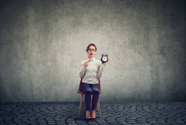 istock Anxious woman with alarm clock waiting for an interview 1014441386