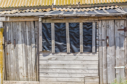 Old rickety wooden shed with slate roof, close-up