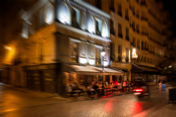 Blurry motion image of people at cafe at night in Paris.