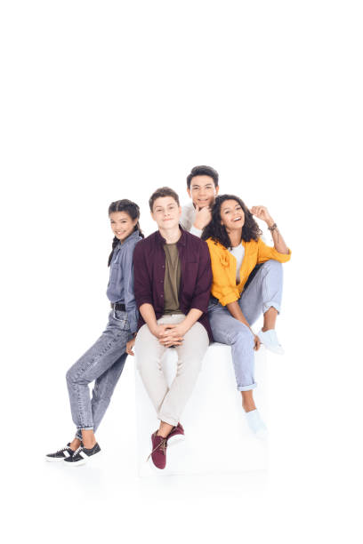 group of happy multiethnic students sitting on white cube isolated on white group of happy multiethnic students sitting on white cube isolated on white teenagers only stock pictures, royalty-free photos & images