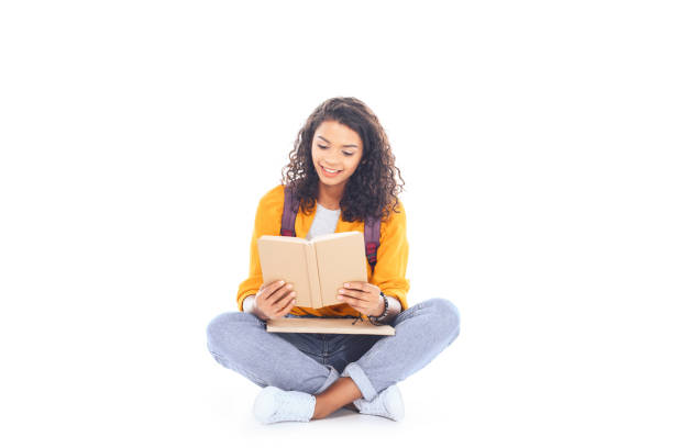 happy african-american woman with bike sitting on street and writing in a notebook