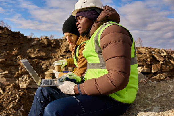 miners using laptop on excavation site - gold digger imagens e fotografias de stock