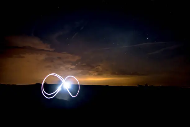 Infinity Symbol with Flashlight unter Nightsky with Stars