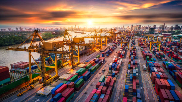 istock Logistics and transportation of Container Cargo ship and Cargo plane with working crane bridge in shipyard at sunrise, logistic import export and transport industry background 1014568480