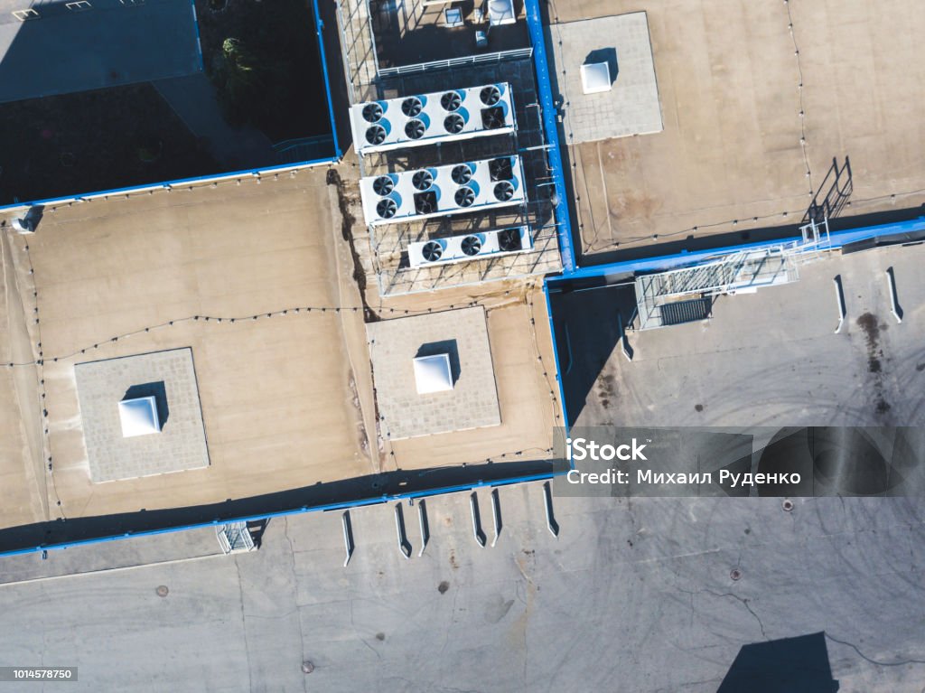 aerial top view of industrial technical system machines on the rooftop of hangar building Consumerism Stock Photo