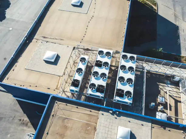 aerial top view of industrial technical system machines on the rooftop of hangar building