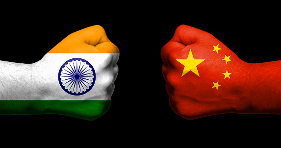 Banderas de India y China pintaron en dos puños apretados uno frente al otro en fondo negro y la India - concepto de las relaciones de China photo