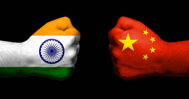 Flags of India and China painted on two clenched fists facing each other on black background/India - China relations concept stock photo