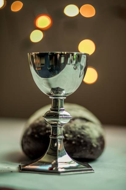 Challis Challis and bread, with blurred background, and lights in the background, christian. anglican eucharist stock pictures, royalty-free photos & images