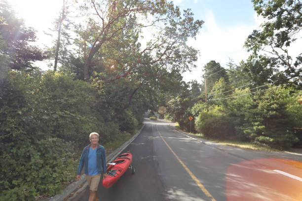 menschen ziehen ozean kajak entlang der urban street - extreme sports kayaking kayak adventure stock-fotos und bilder