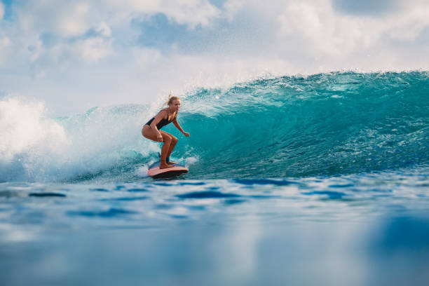 istock Attractive woman on surfboard during surfing. Surfer and ocean wave 1014587880