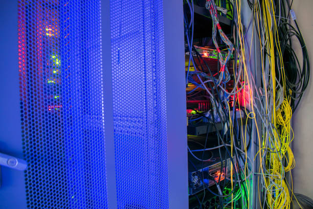 istock Messy wires are in the switch rack. A bright display glows on the computer equipment in the data center server room. 1014596072