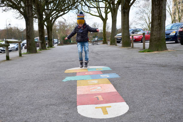 Kid playing hopscotch on playground