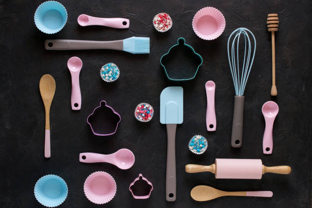 Baking and cooking concept. Pattern made of cookie cutters, whisk, roller pin and kitchen bake tools for making sweets. Dark  background. Top view of a holiday baking still life
