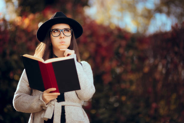 istock Hipster Student Holding a Book Outdoors in Autumn Decor 1014616258