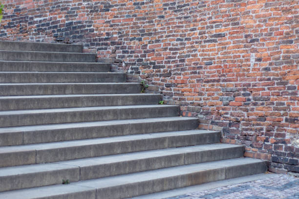 istock Old stone staircase against a brick wall background 1014627162