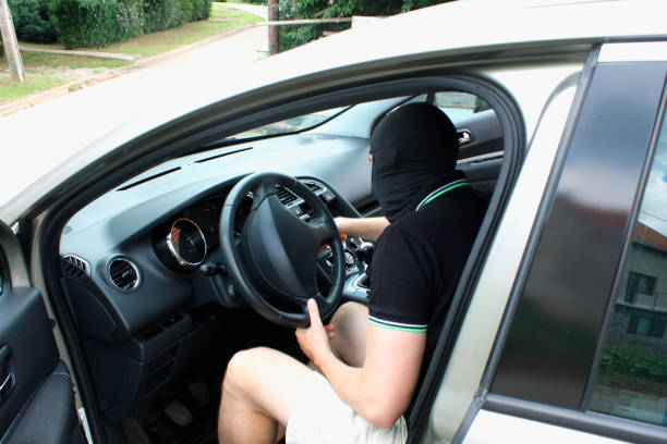 istock The malefactor in the mask stealing car 1014627544