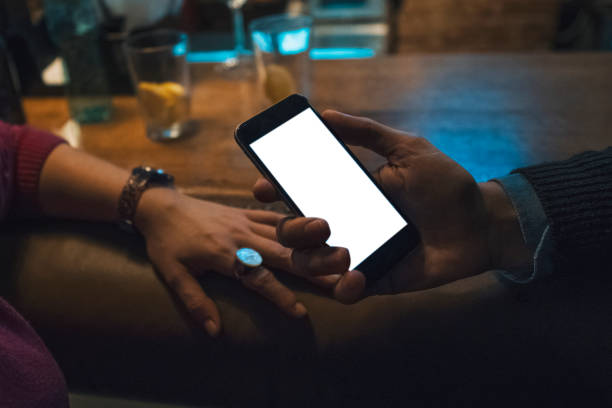 istock Man holding a smartphone in a bar with copy space 1014637556