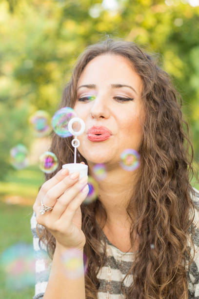 istock young girl in the park blowing bubbles 1014641034
