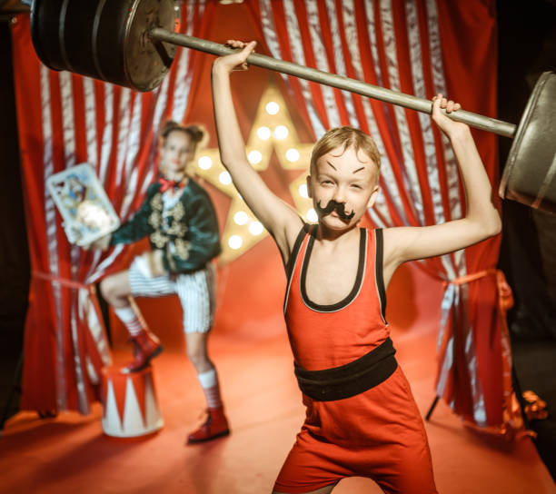 istock Strongman Boy Shows His Strength in Retro Circus Performance 1014646318