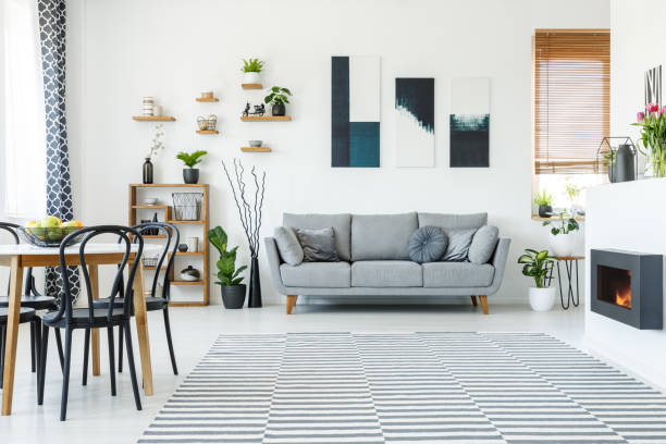 istock Black chairs at table in spacious apartment interior with posters above grey sofa. Real photo 1014648832