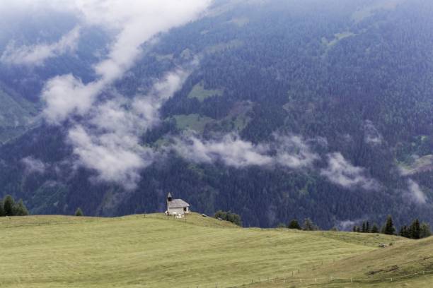 istock Cloudy alpine landscape with a small chapel 1014649240