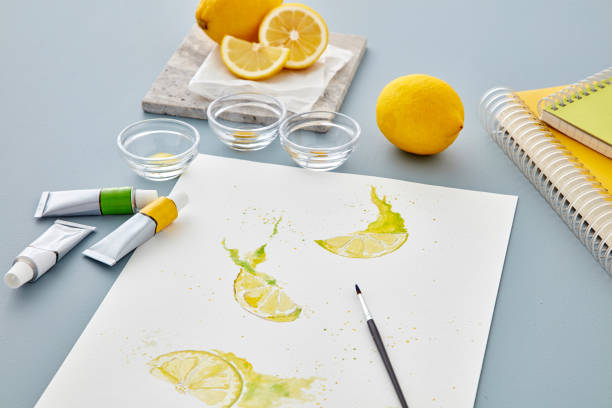 Lemon painting with watercolors and plastic paint palette, brush, watercolor stock photo