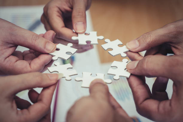 istock Team placing four puzzles jigsaw together for team concept 1014658094