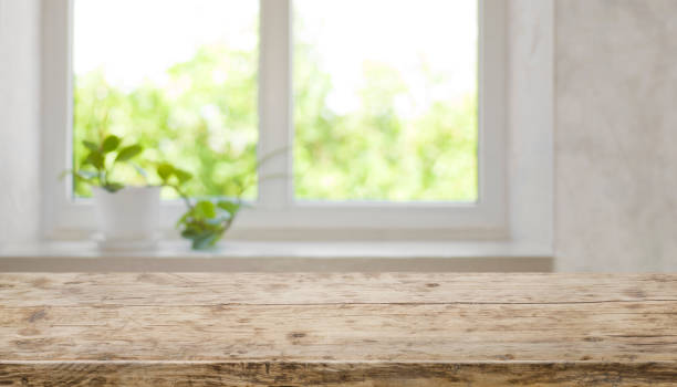 istock Brown aged wooden tabletop with blurred window for product display 1014658130