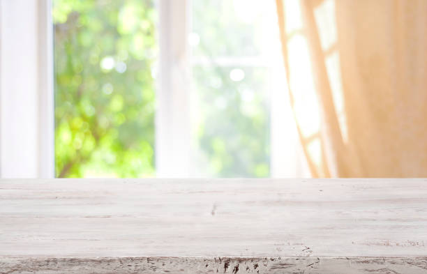 Wooden table top on blurred window background for product display
