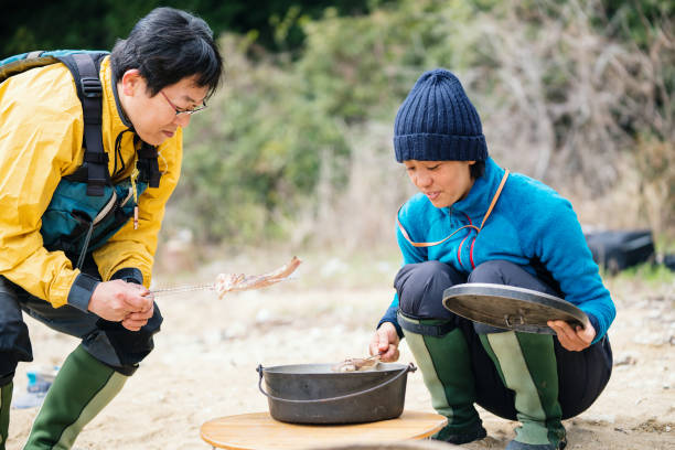 istock Man cooking and preparing lunch on a beach after sea kayaking 1014664296