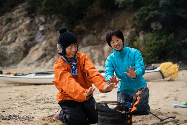 istock Two women warming up by a fire after sea kayaking 1014664372
