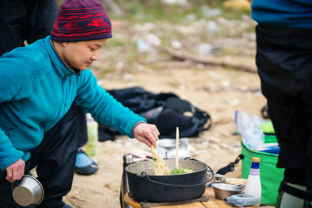 istock Man cooking and preparing lunch on a beach after sea kayaking 1014664468