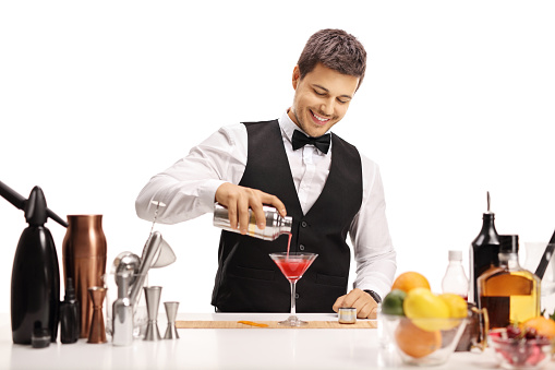 Barman pouring his signature cocktail in a glass isolated on white background
