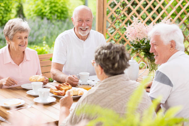 istock Happy and smiling senior people having fun while eating breakfast with friends 1014667528