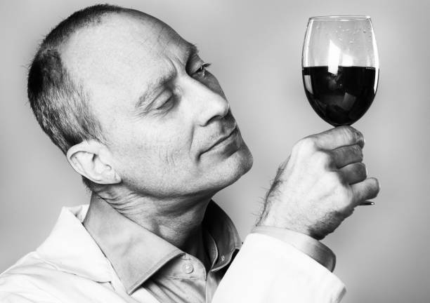 istock Man in lab coat holds wine glass up to light 1014667572