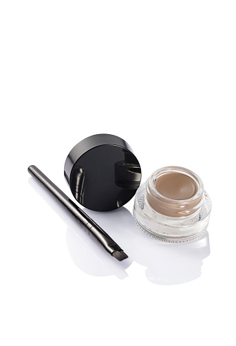 Black make-up brushes on a gray background