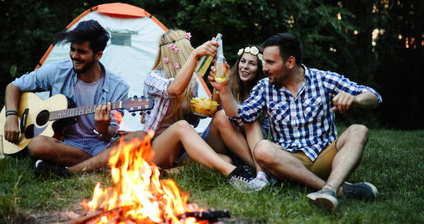 istock Happy friends playing music and enjoying bonfire 1014667886