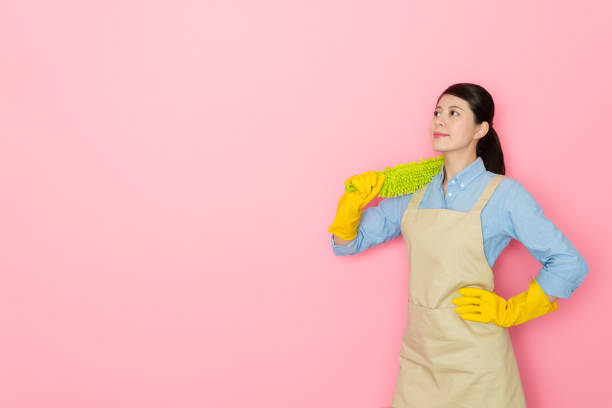 istock smiling woman housekeeper carrying feather duster 1014676426