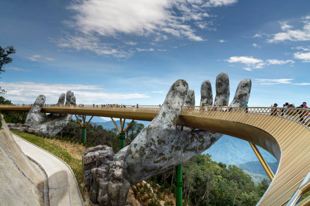 the golden bridge is lifted by two giant hands in the tourist resort on ba na hill in danang, vietnam. - rio carnival fotos imagens e fotografias de stock