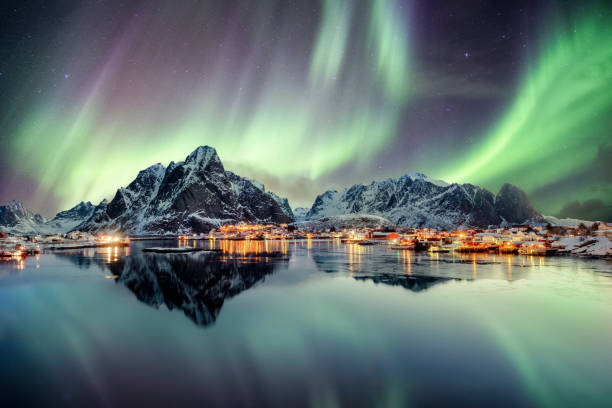 aurora borealis tanzen auf berg in fischerdorf - norwegen stock-fotos und bilder