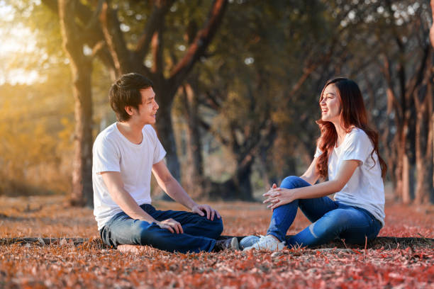 istock young couple talking and laghing in the park 1014687578