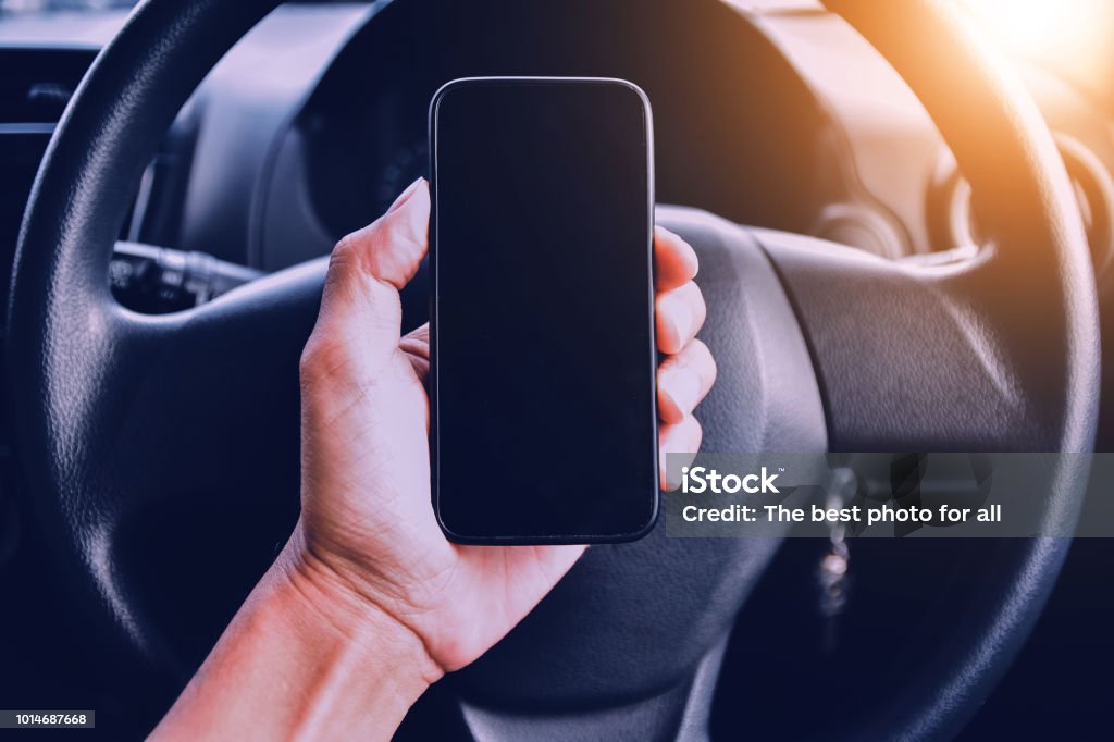 Hand holding smartphone in car parked on street.And using smartphone to shopping online by internet Map Stock Photo