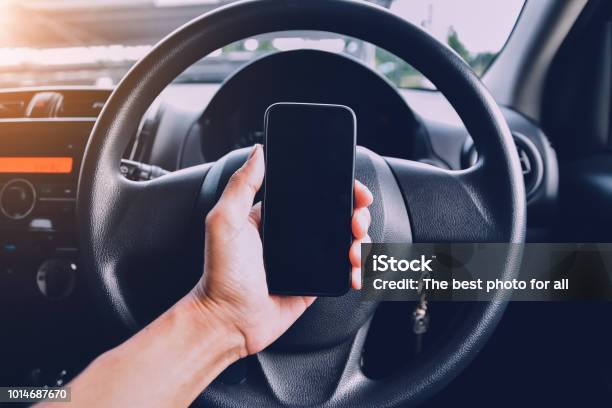 Hand Holding Smartphone In Car Parked On Streetand Using Smartphone To Shopping Online By Internet Stock Photo - Download Image Now