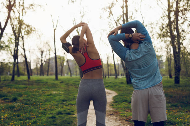 istock Fit athlete couple doing stretching exercises on running track 1014690318